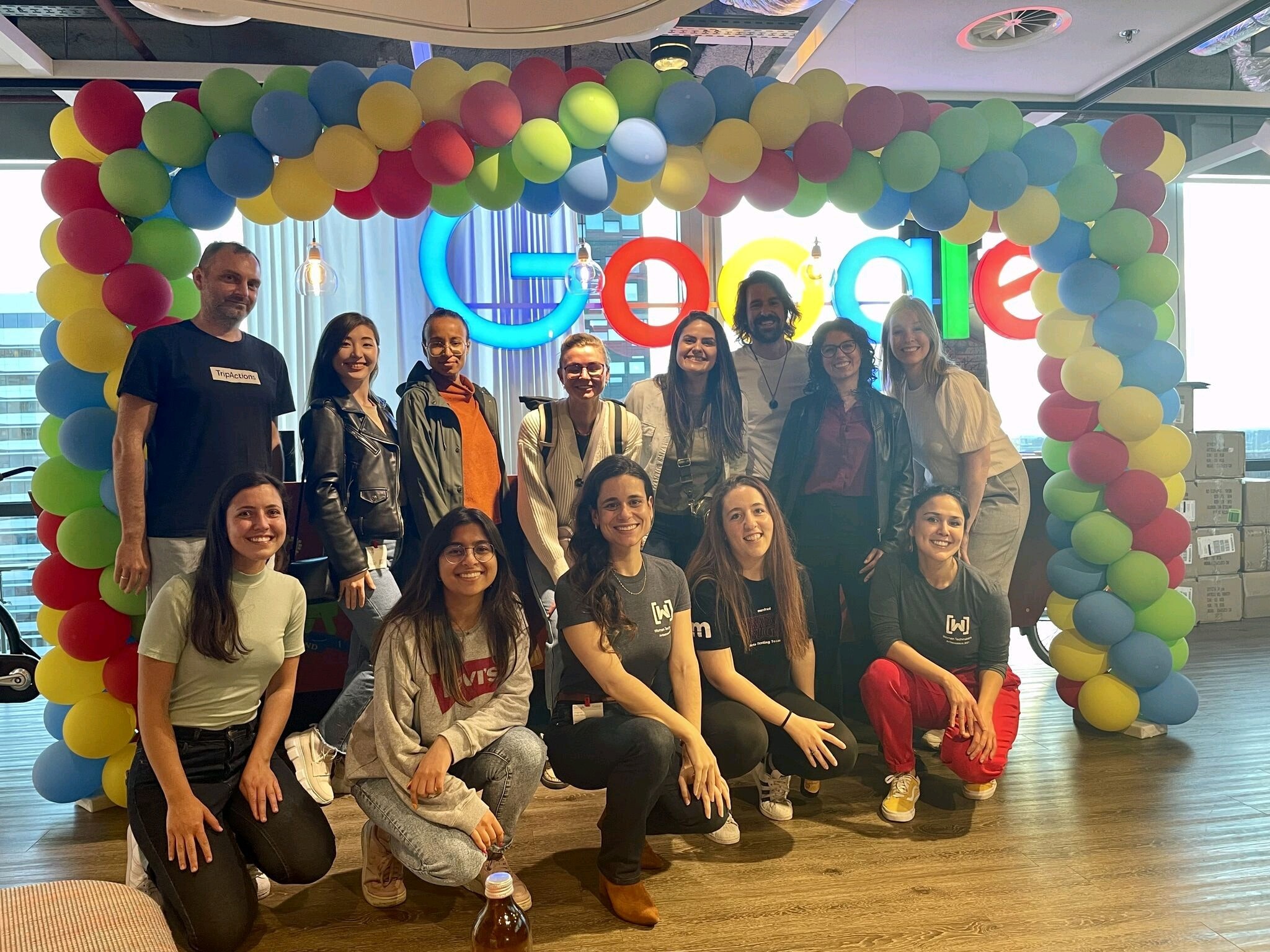 Alba e outros participantes em frente a uma placa do Google.