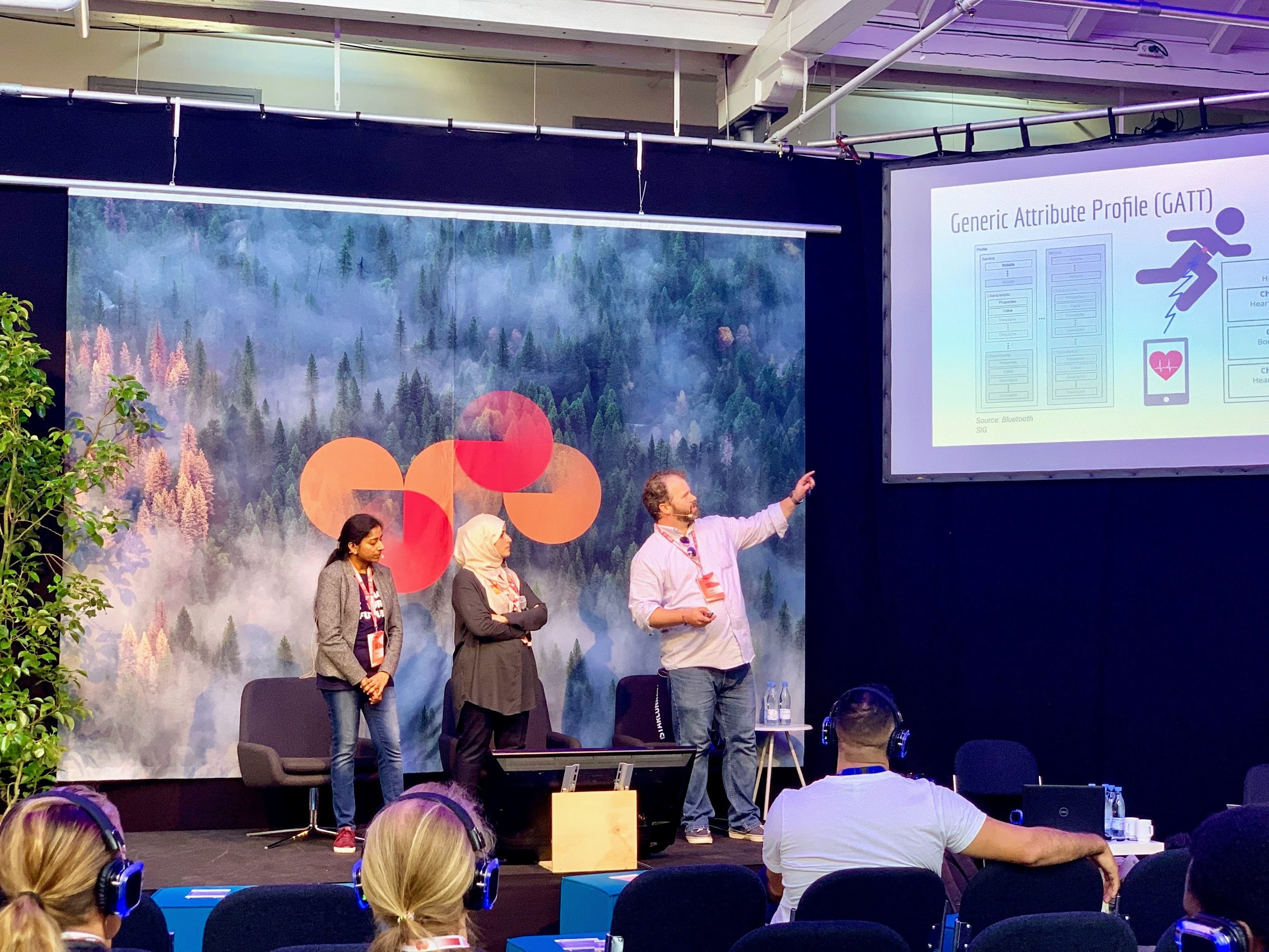 Lars presenta en el escenario con otros dos oradores.