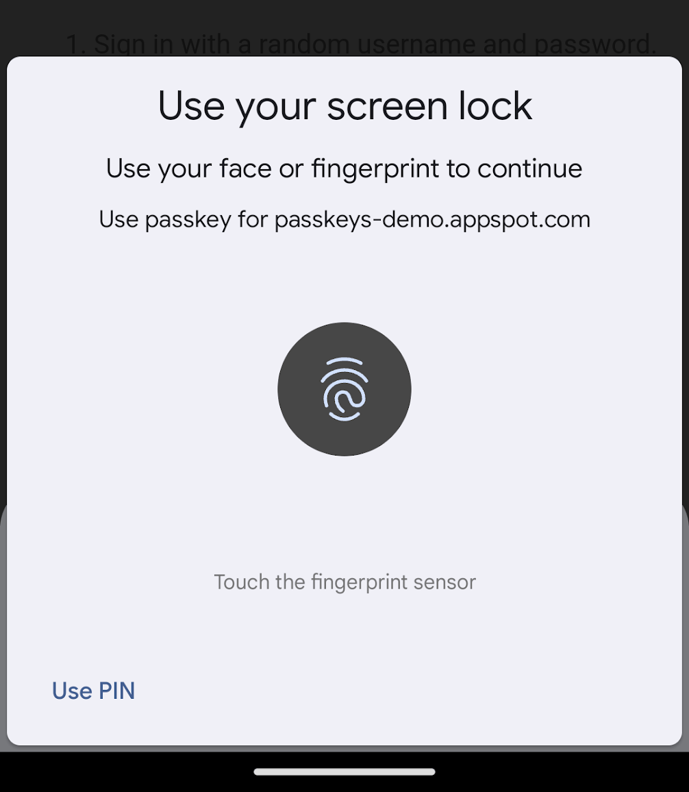 Screenshot dialog verifikasi pengguna di Chrome untuk Android. Dialog akan meminta pengguna untuk memverifikasi identitas mereka menggunakan pengenalan wajah atau deteksi sidik jari, dan menampilkan asal yang meminta autentikasi. Di kiri bawah terdapat opsi untuk memverifikasi menggunakan PIN.