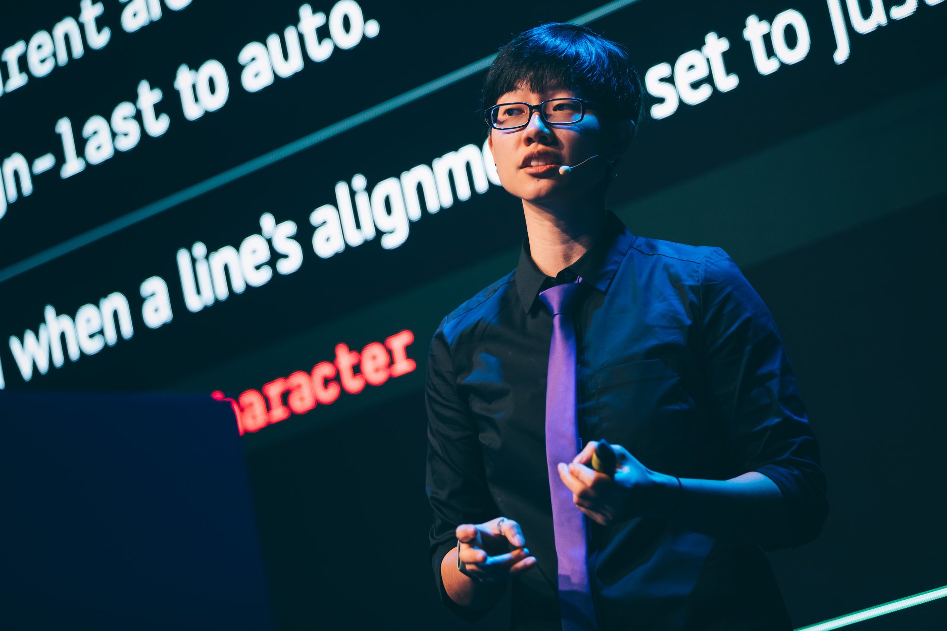 Chen Hui Jing hablando en un escenario frente a una pantalla grande en la que se muestran diapositivas.